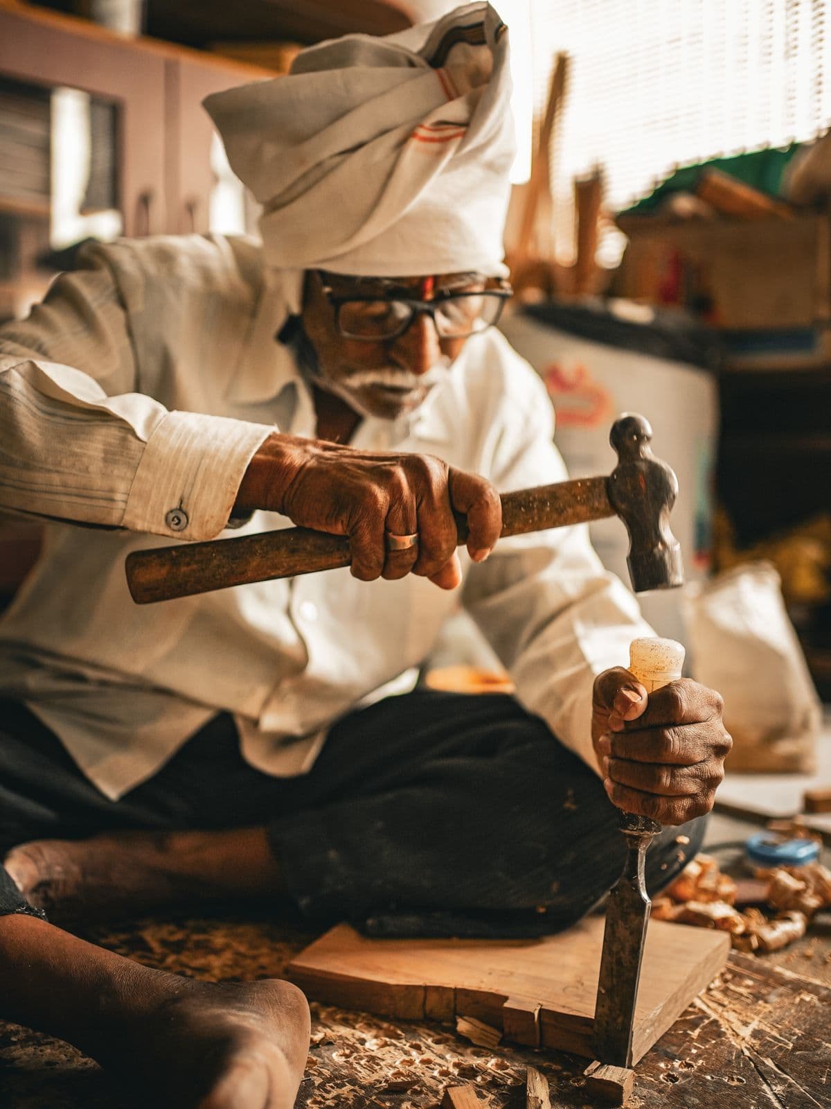 A carpenter chiselling wood in his workshop