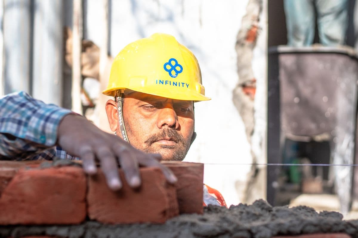 A mason laying bricks on a building site