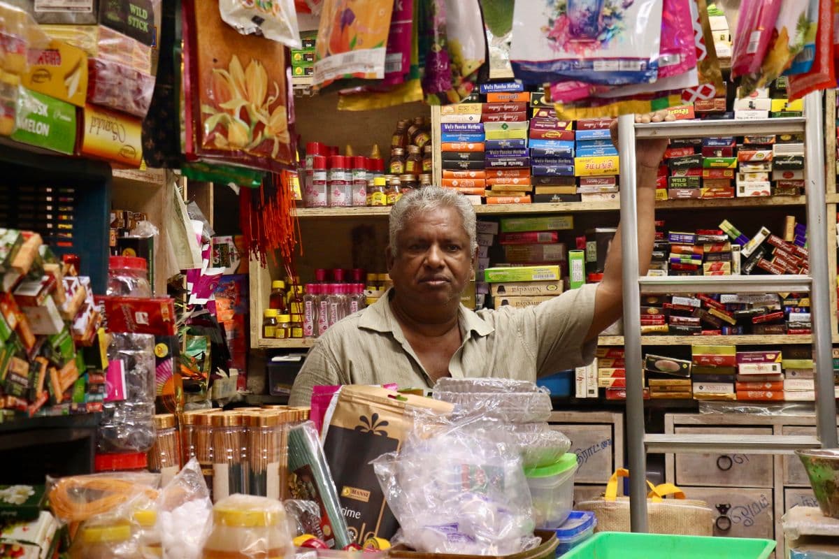 A shopkeeper at the counter of his neighbourhood store